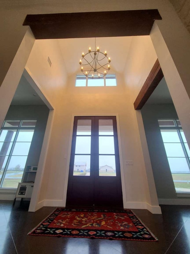 entryway featuring french doors, a wealth of natural light, and a notable chandelier