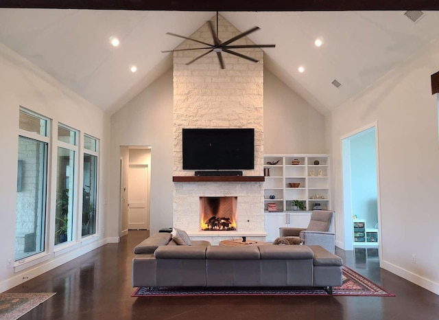 living room with ceiling fan, dark hardwood / wood-style flooring, a stone fireplace, and high vaulted ceiling