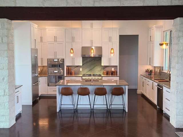 kitchen with a kitchen breakfast bar, stainless steel appliances, white cabinetry, and a kitchen island with sink