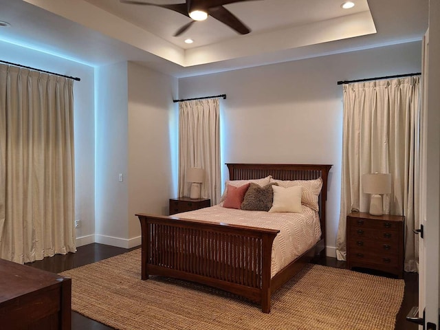 bedroom with ceiling fan, hardwood / wood-style flooring, and a raised ceiling