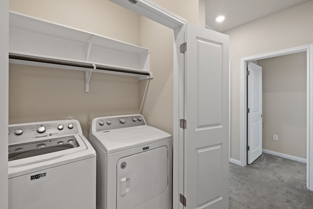 laundry area featuring washing machine and dryer and light carpet