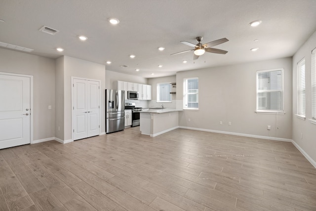 unfurnished living room with ceiling fan and light hardwood / wood-style flooring