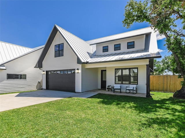 modern inspired farmhouse with a porch, a front yard, and a garage