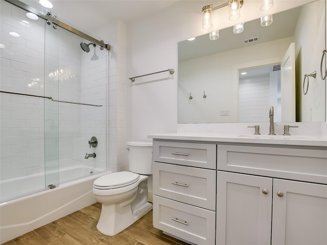 full bathroom featuring shower / bath combination with glass door, vanity, and toilet