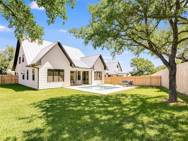 back of house featuring a yard, a fenced in pool, and a patio area