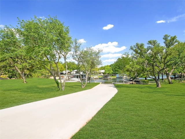 view of home's community featuring a water view and a lawn