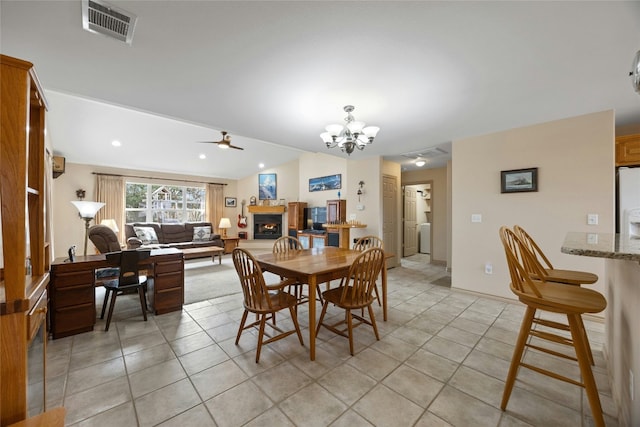 1505 E Johnson St, Burnet, TX 78611 - dining room with a chandelier, a ceiling fan, a glass covered fireplace, light tile patterned floors, and vaulted ceiling
