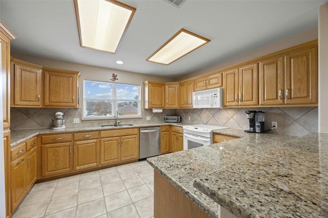 kitchen featuring sink, backsplash, light tile patterned floors, light stone countertops, and white appliances