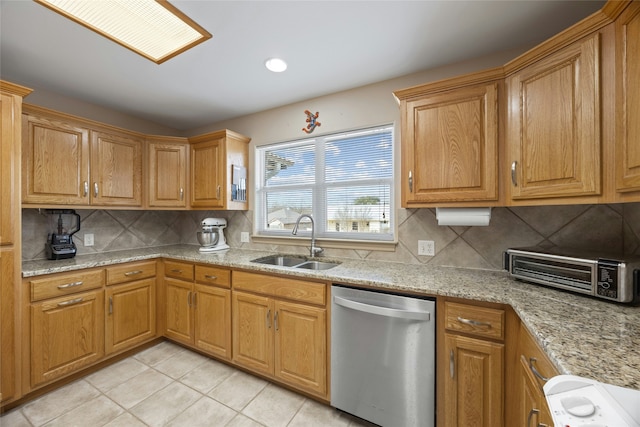 kitchen featuring sink, tasteful backsplash, light tile patterned floors, dishwasher, and light stone countertops