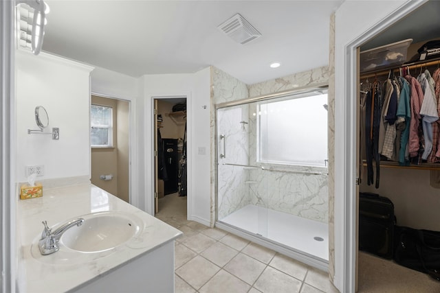 bathroom featuring tile patterned flooring, vanity, and a shower with shower door