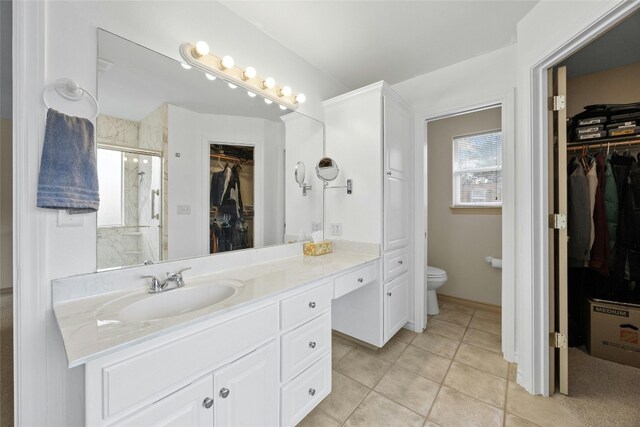 bathroom featuring walk in shower, tile patterned floors, vanity, and toilet