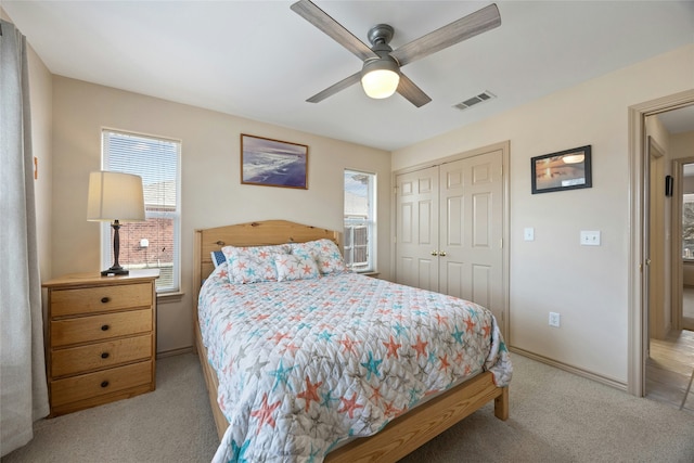 carpeted bedroom with ceiling fan and a closet