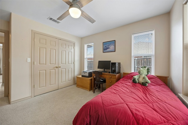 carpeted bedroom with ceiling fan and a closet