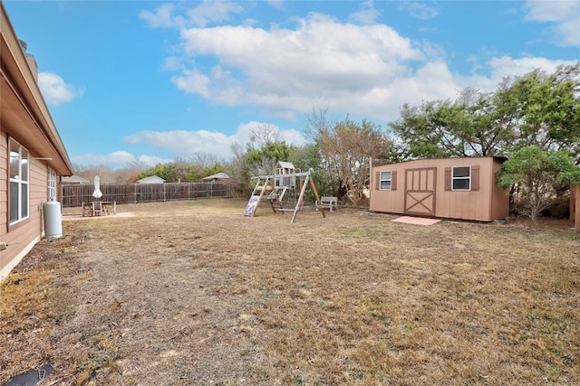 view of yard featuring an outbuilding, a shed, a playground, and a fenced backyard