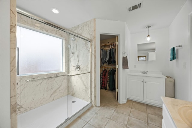 1505 E Johnson St, Burnet, TX 78611 - bathroom featuring vanity, a marble finish shower, tile patterned floors, and a spacious closet
