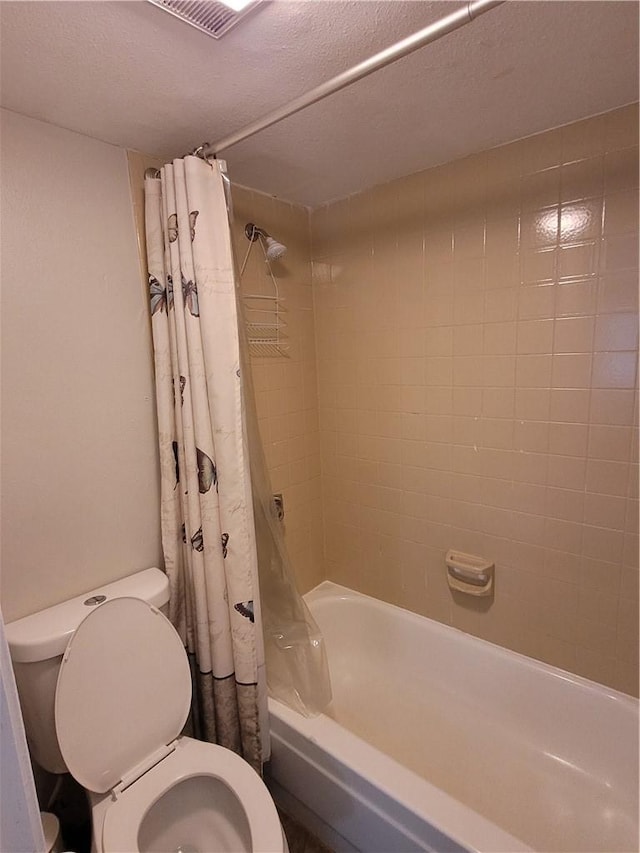 bathroom featuring toilet, a textured ceiling, and shower / bathtub combination with curtain