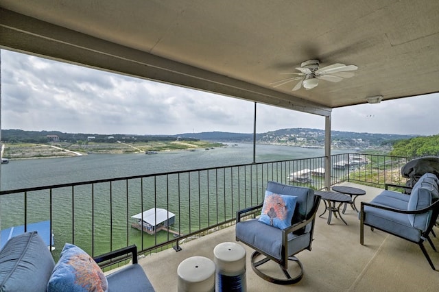 balcony featuring ceiling fan, a water view, and an outdoor hangout area