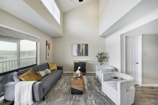 living room with dark hardwood / wood-style flooring, high vaulted ceiling, and plenty of natural light