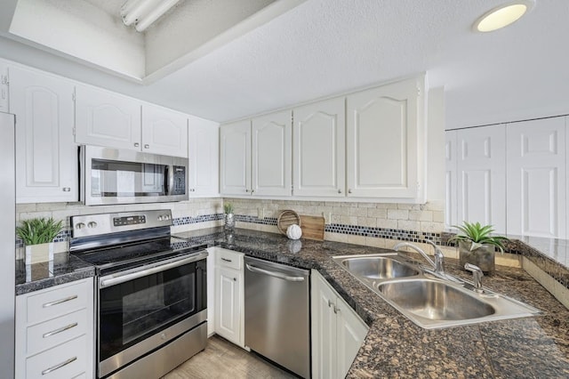 kitchen with sink, white cabinetry, tasteful backsplash, and appliances with stainless steel finishes