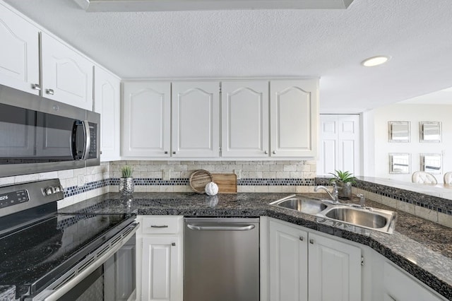 kitchen featuring stainless steel appliances, white cabinetry, sink, and a textured ceiling