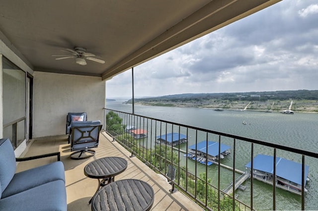 balcony with ceiling fan, an outdoor living space, and a water view