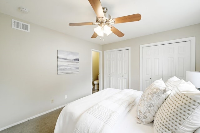 carpeted bedroom featuring multiple closets and ceiling fan