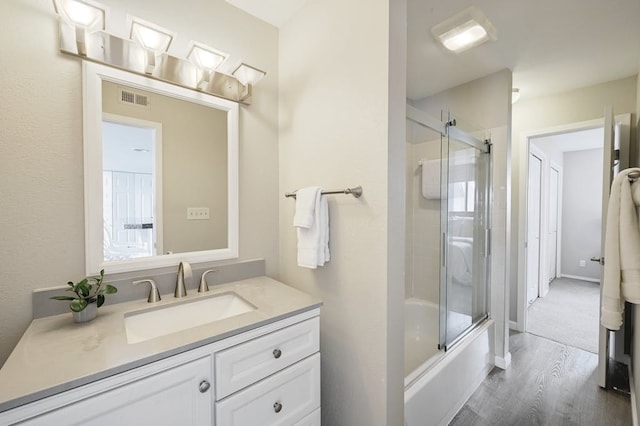 bathroom with vanity, enclosed tub / shower combo, and hardwood / wood-style floors