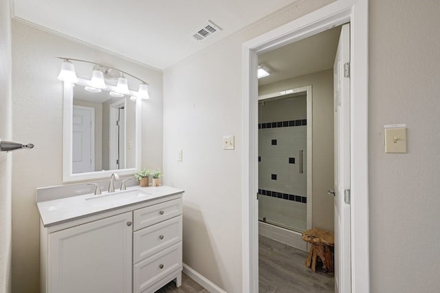 bathroom with an enclosed shower, wood-type flooring, and vanity