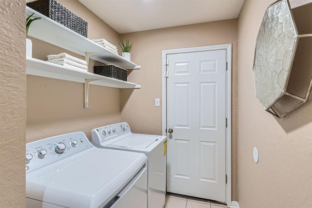 laundry room with light tile patterned flooring and washing machine and clothes dryer