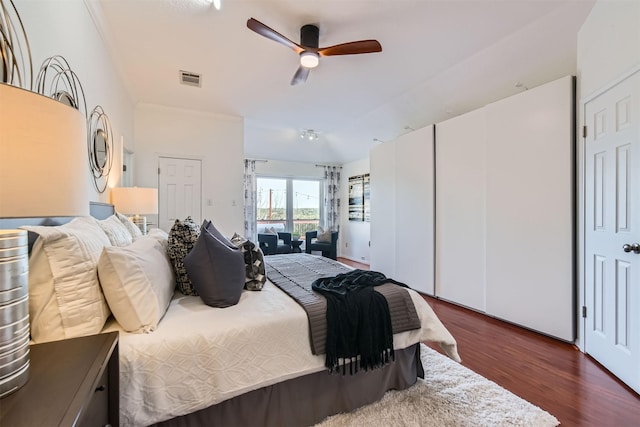 bedroom with ceiling fan, vaulted ceiling, ornamental molding, and dark hardwood / wood-style floors