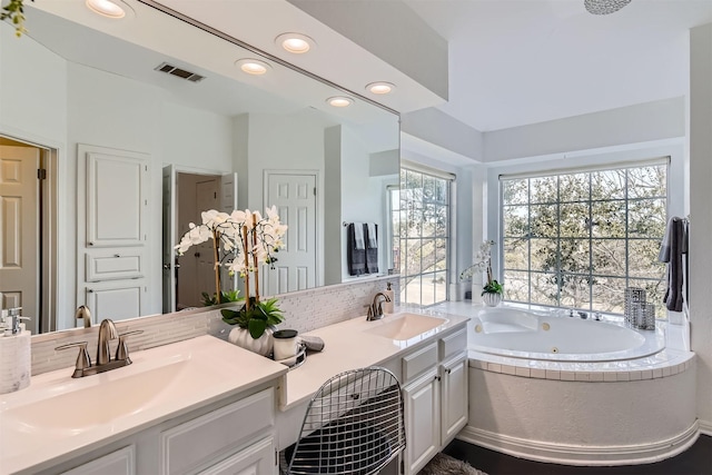 bathroom featuring vanity and a washtub