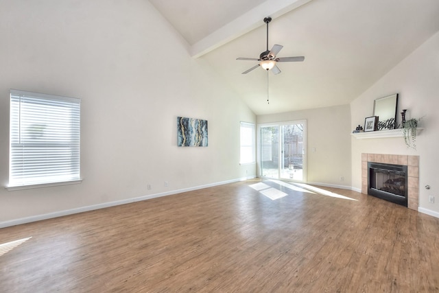 unfurnished living room with hardwood / wood-style floors, ceiling fan, high vaulted ceiling, a fireplace, and beam ceiling