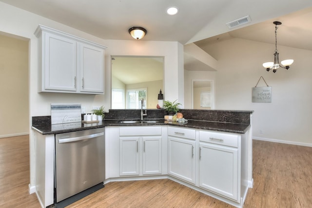 kitchen with sink, white cabinets, lofted ceiling, stainless steel dishwasher, and dark stone counters