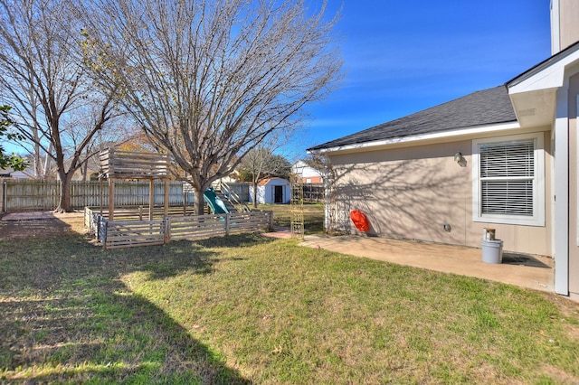 view of yard with a storage shed and a patio