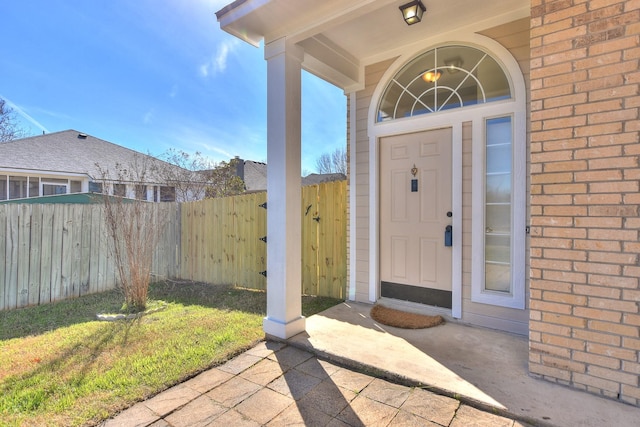 entrance to property with a patio and a lawn