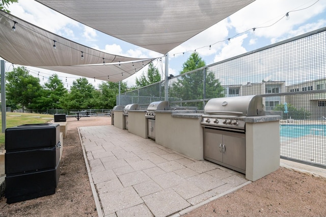 view of patio with a grill, a fenced in pool, and area for grilling