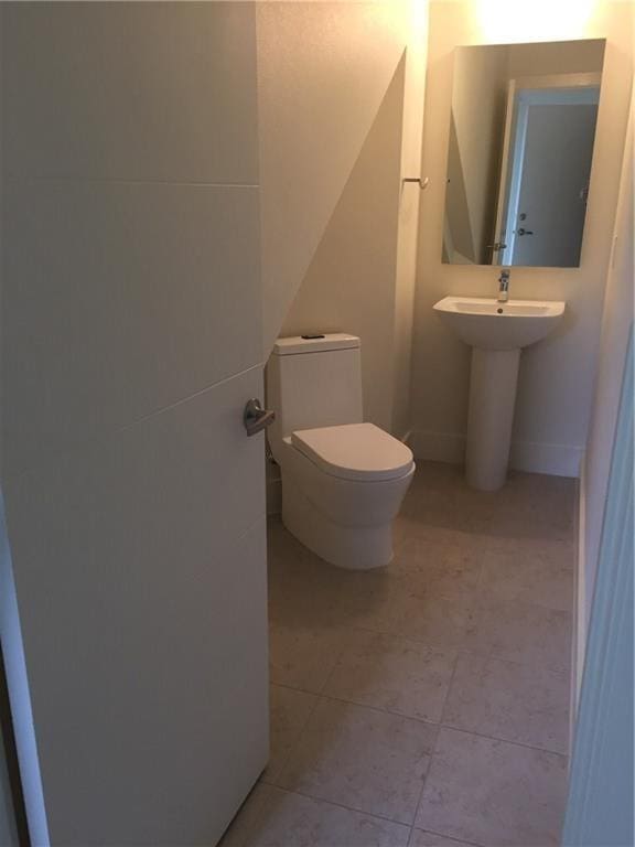 bathroom with toilet and tile patterned flooring