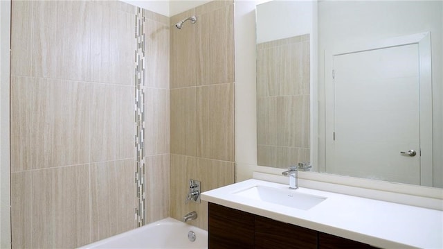 bathroom with tiled shower / bath combo and vanity