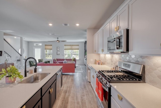 kitchen featuring stainless steel appliances, white cabinetry, and sink