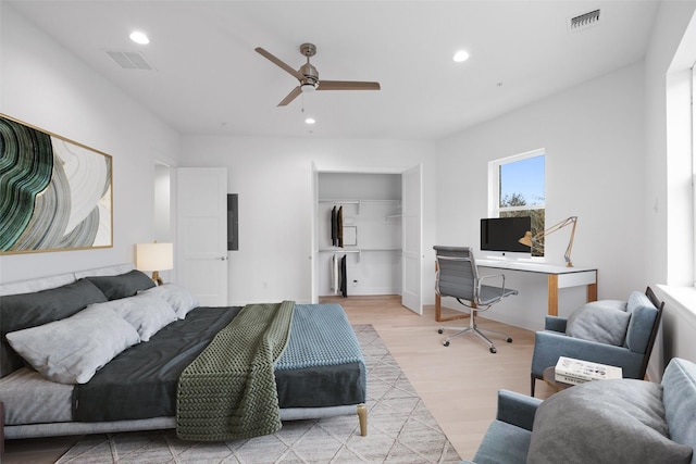 bedroom featuring ceiling fan, light wood-type flooring, a closet, and electric panel