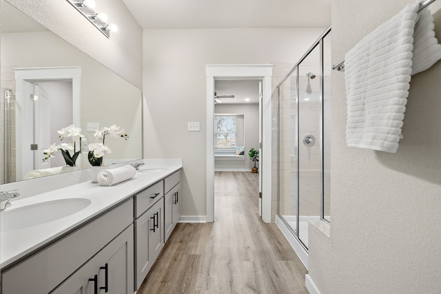 2213 Rocoso Trl, Leander, TX 78641 - bathroom with wood finished floors, double vanity, and a shower stall