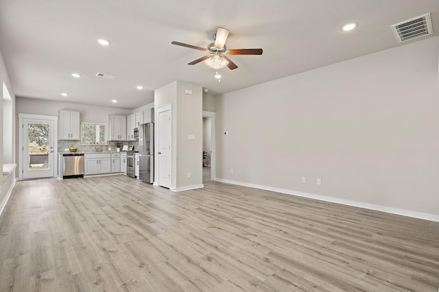 unfurnished living room featuring ceiling fan and light hardwood / wood-style floors