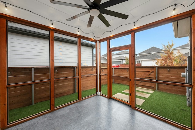 unfurnished sunroom featuring ceiling fan