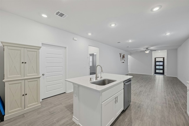 kitchen featuring white cabinetry, sink, a kitchen island with sink, ceiling fan, and stainless steel dishwasher