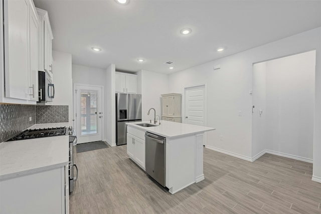 kitchen featuring white cabinets, a kitchen island with sink, and appliances with stainless steel finishes