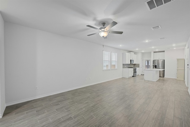 unfurnished living room with ceiling fan