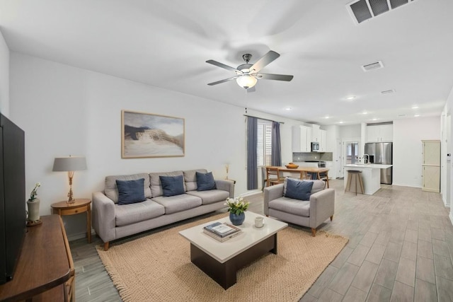 living area with light wood-style flooring, recessed lighting, a ceiling fan, and visible vents