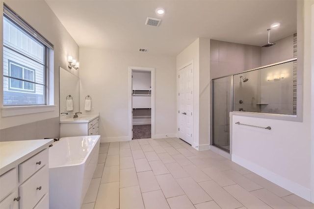 full bath with a stall shower, visible vents, baseboards, a walk in closet, and vanity