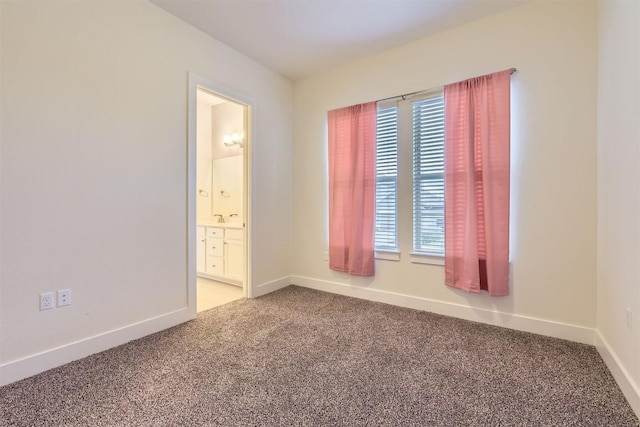 unfurnished room featuring carpet and baseboards