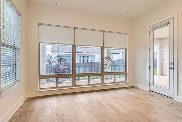 spare room featuring light wood-type flooring and baseboards